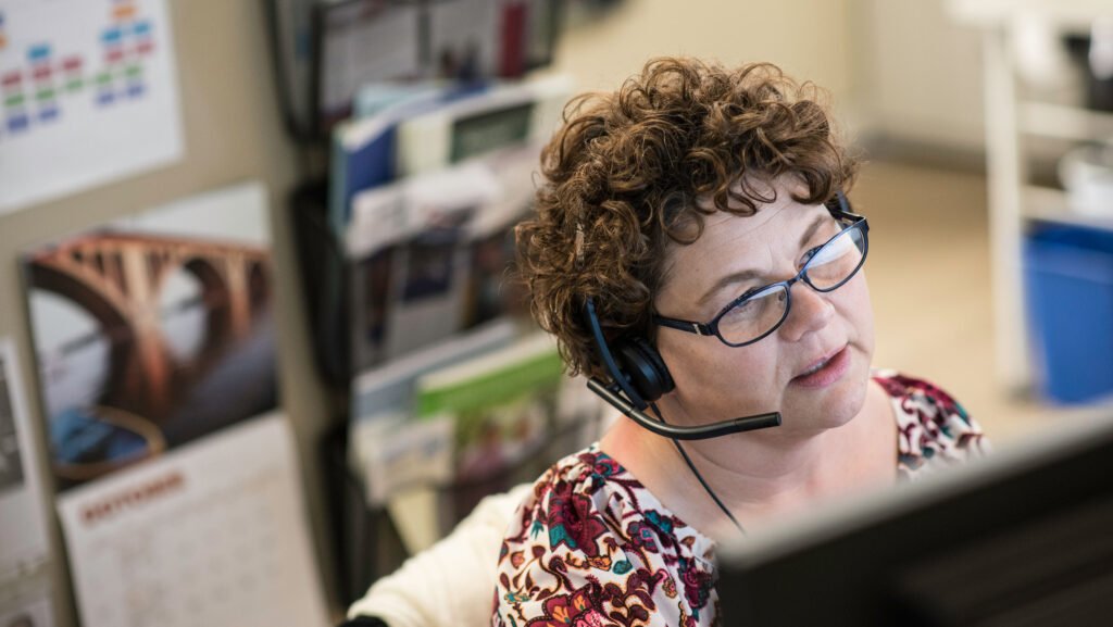 Trellis employee wearing headset answering call to Senior LinkAge Line.