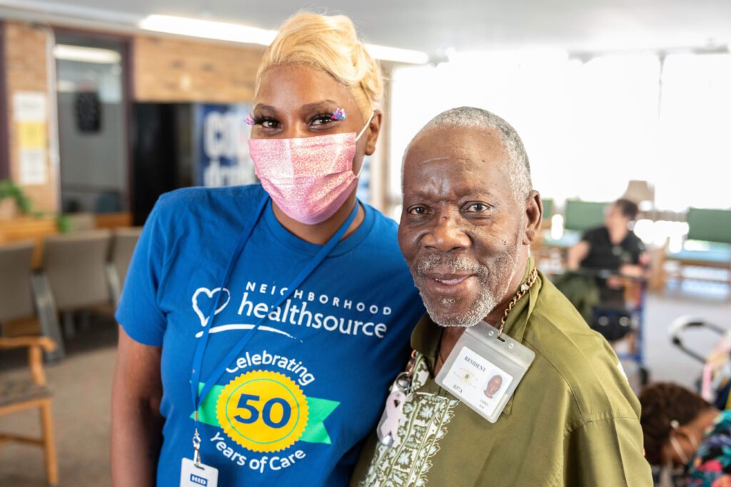Healthcare worker and resident man attending a Trellis outreach event in a pose that show comfortable and caring relationship